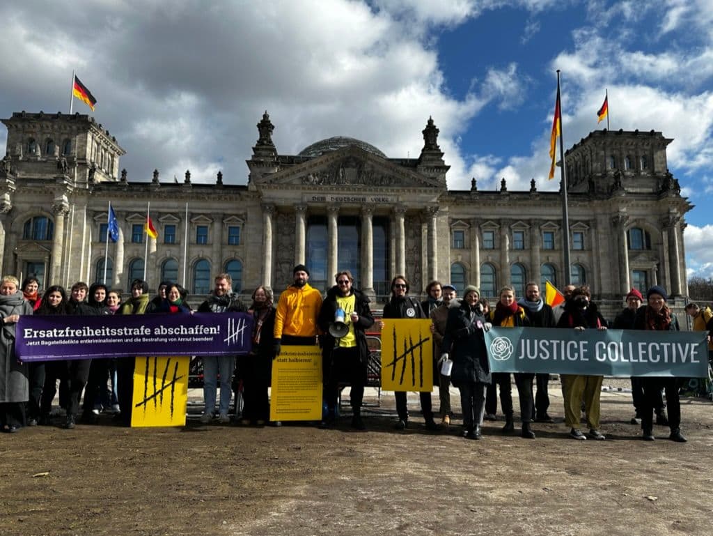 Coalition protesting outside of Bundestag with signs for abolishing Ersatzfreiheitsstrafe and Justice Collective